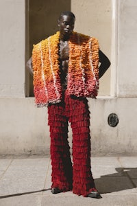 a man in a colorful outfit standing on a street