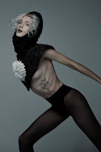 a woman in black stockings posing on a grey background