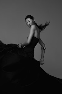 a black and white photo of a woman in a dress